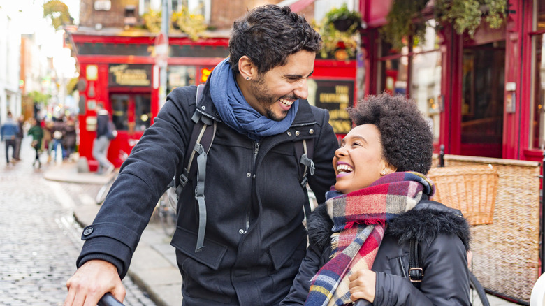 Couple laughing in front of Temple Bar in Dublin, Ireland