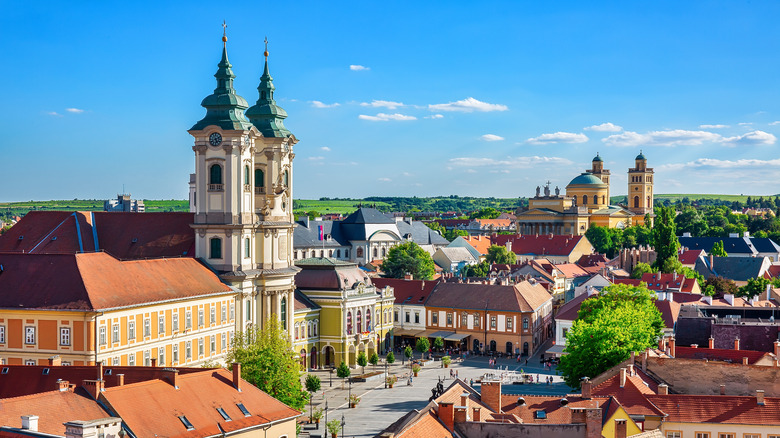 Dobó Square Eger baroque church towers with colorful buildings against blue sky