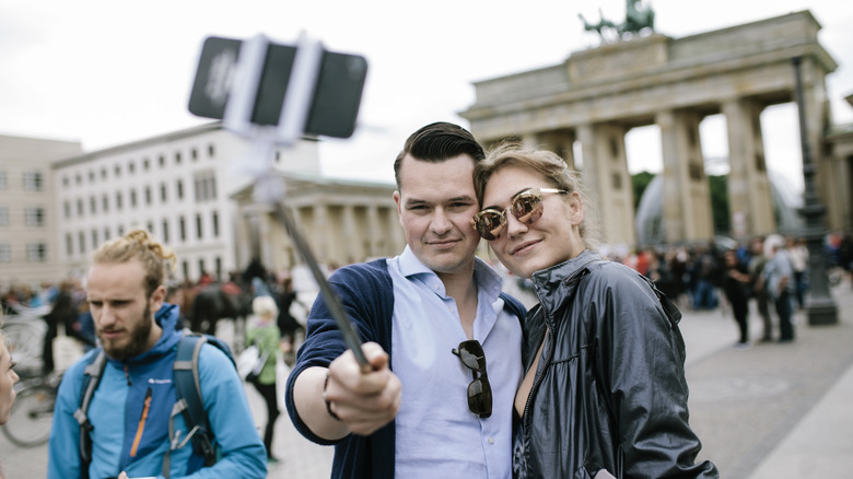 Couple uses selfie stick at Brandenburg Gate