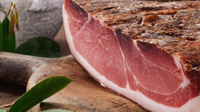 A whole speck pork cutlet with fatty marbling in Italy
