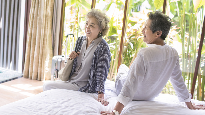 An older couple lounge on hotel resort bed