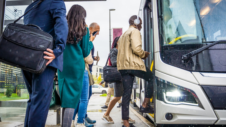 Passengers wait in line to board a city