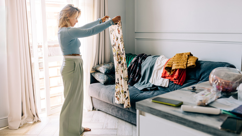 Woman laying out all her clothing as she packs for a trip