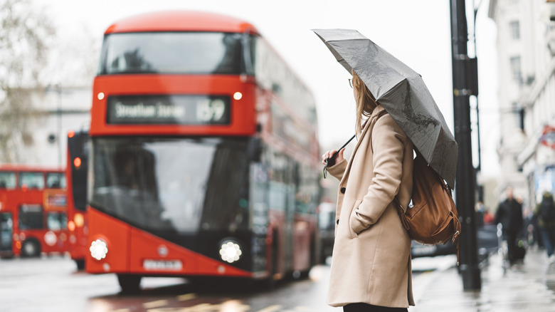 Woman waiting for the bus on a rainy day in London