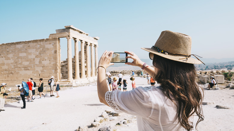 Person sightseeing and taking pictures of ancient ruins in Athens, Greece