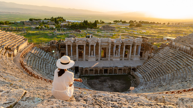 Woman with hat watching the sunset at Hierapolis Pamukkale in Turkey