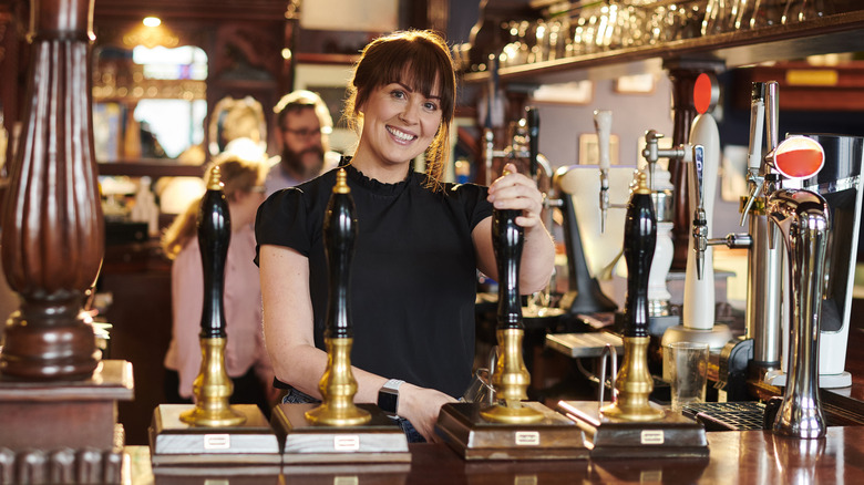 Woman pulling a real pub ale with a long handle