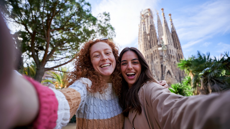 Two girls taking a selfie with the Sagrada Familia in the backdrop