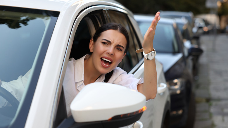 Angry driver waving from her car