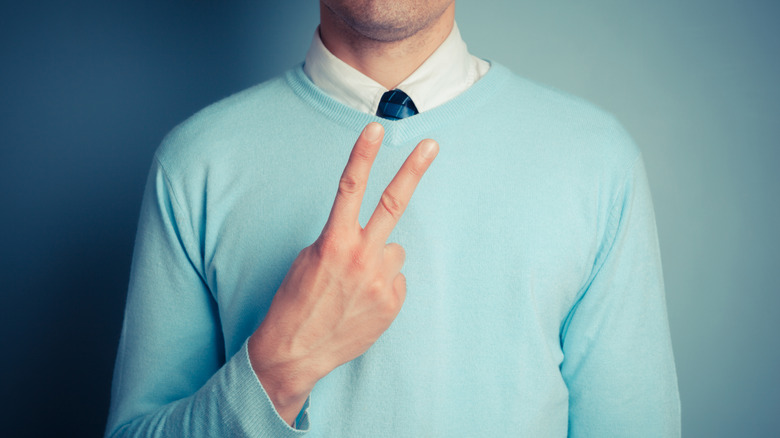 Man raising two fingers in v for vitory or peace sign