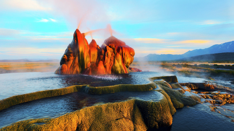 mineral rock formations spew water surrounded by pools