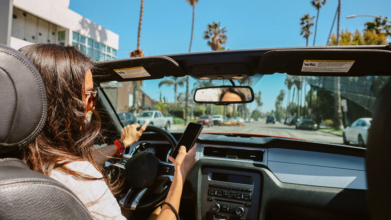 Woman checking her phone in a car