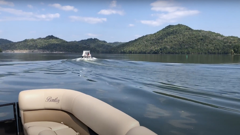 Boats on Cordell Hull Lake day time with green hills