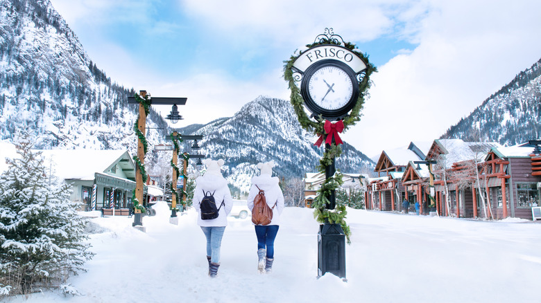 People walking in the snow next to a clock labeled "Frisco."