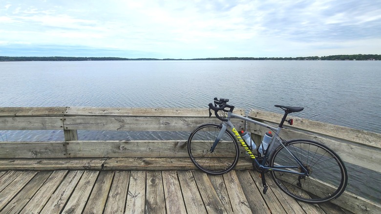 A bicycle leans against the wooden railing of a boardwalk over a lake along the Glacial Drumlin Trail in Wisconsin