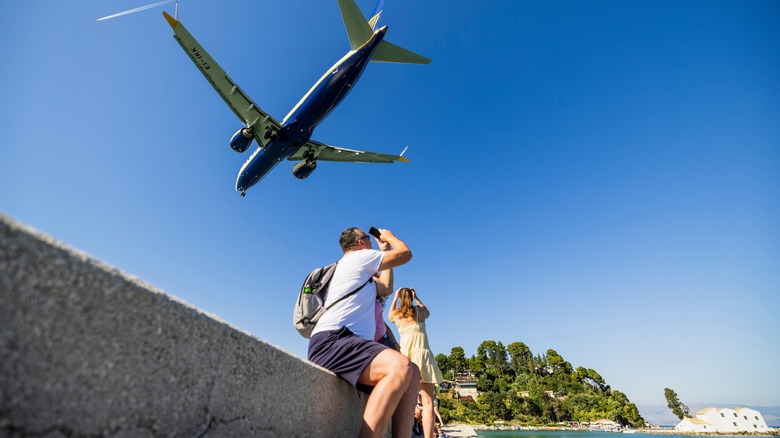 A Ryanair flight jets over the heads of two people