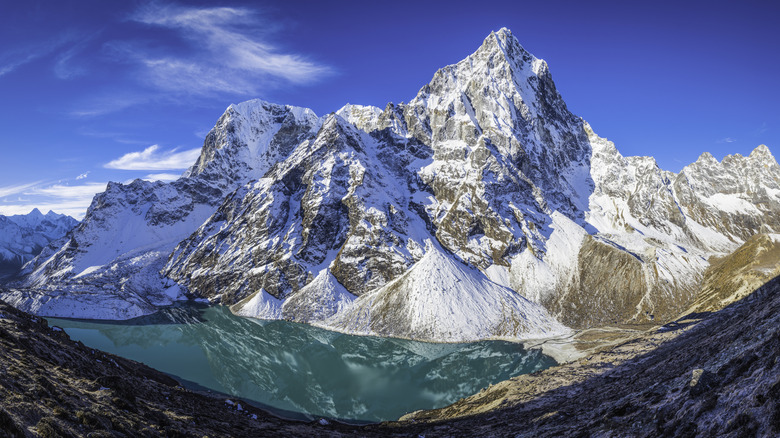Soaring snow-capped mountains above a milky blue lake in Sagarmatha National Park in Nepal