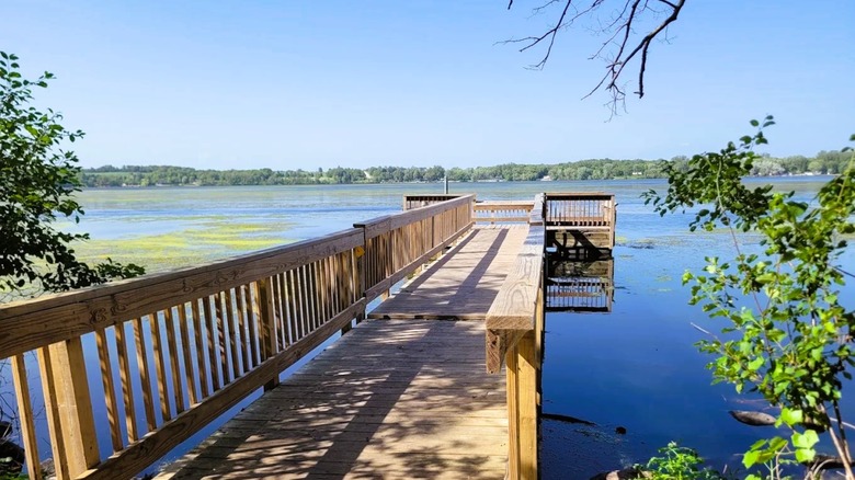 A wooden pier at Sakatah Lake State Park in Minnesota, with views the lake and a lush shoreline in the distance.