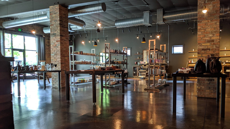 A warehouse-style store with concrete floors, brick columns, and and merchandise on steel tables