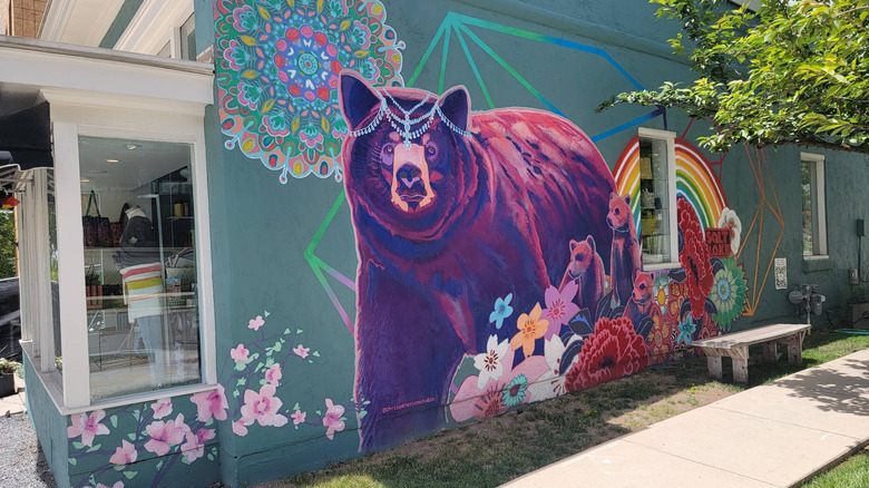 A mural of a multi-colored bear wearing a tiara on the side of a local business in Salt Lake City