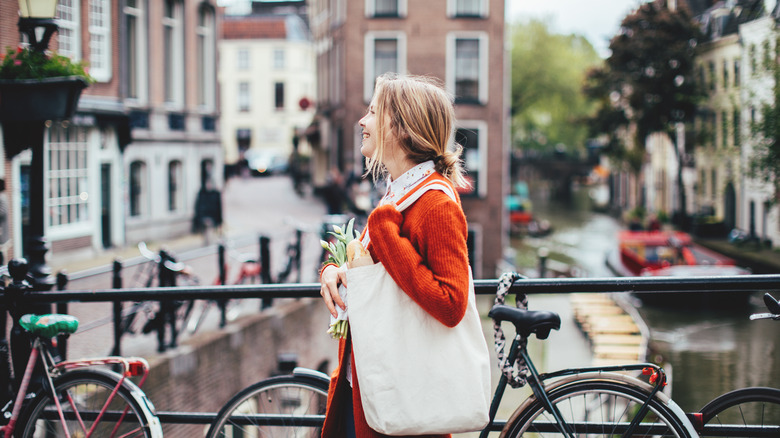 Woman walking on bridge with tulips