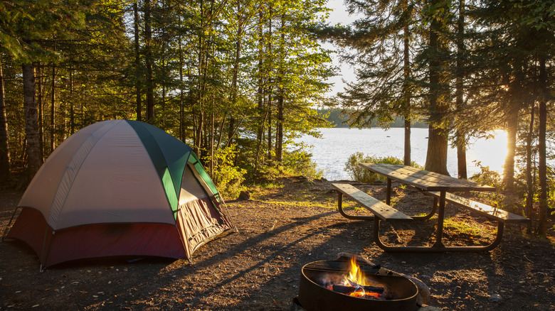 Camping setup with campfire near a lake