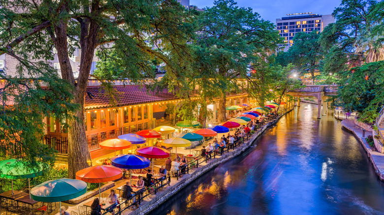 Aerial view of people dining along San Antonio River Walk in evening