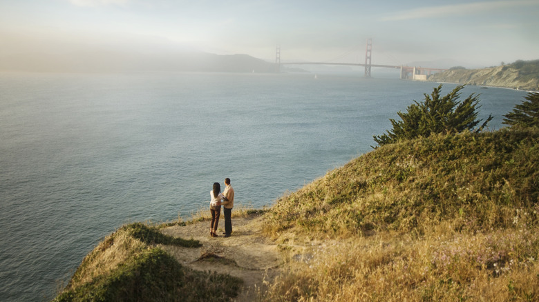 Two people on a trail on Angel Island State Park with the Golden Gate Bridge in the background