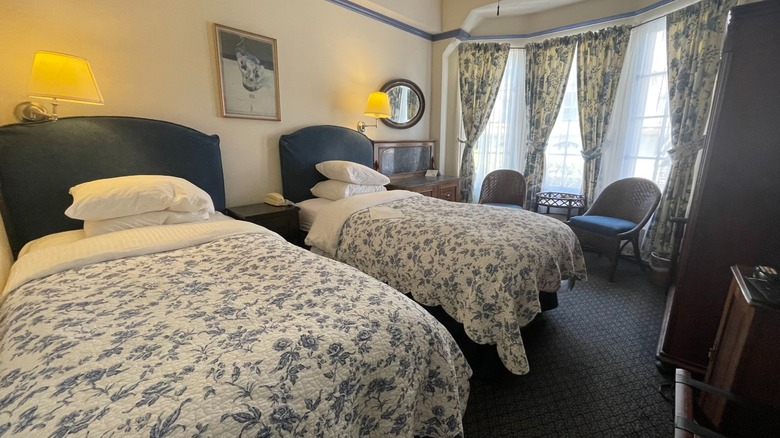 A historic hotel room with twin beds and bay windows at Golden Gate Hotel, San Francisco.