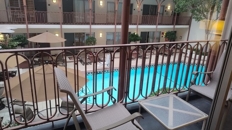 A balcony with two chairs overlooks a swimming pool in the courtyard of the Handlery Union Square Hotel in San Francisco.