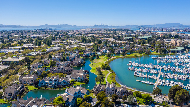 Sailboats in the marina and luxury homes along the shoreline in Alameda, California