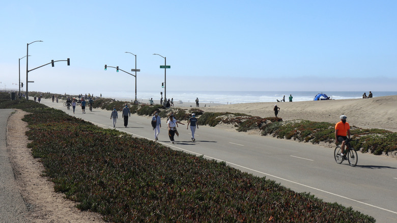 People walking on the Upper Great Highway in San Francisco, with the beach behind them