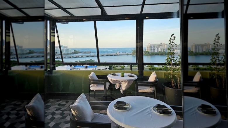 Set tables in a dining room overlooking the water in Canvas restaurant, San Juan