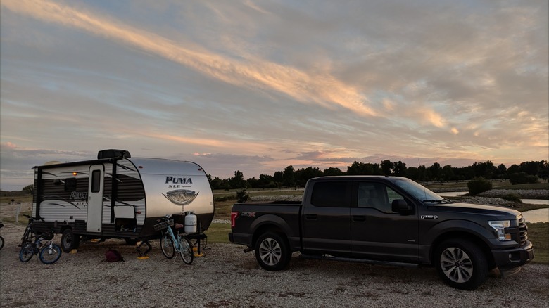 Campground at Sand Hills State Park, Kansas, with a truck and trailer parked on the gravel during sunset