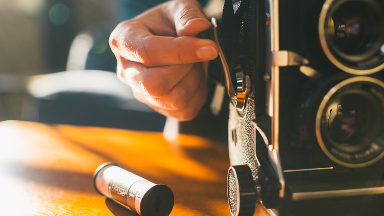 Hand on a crank on a vintage camera