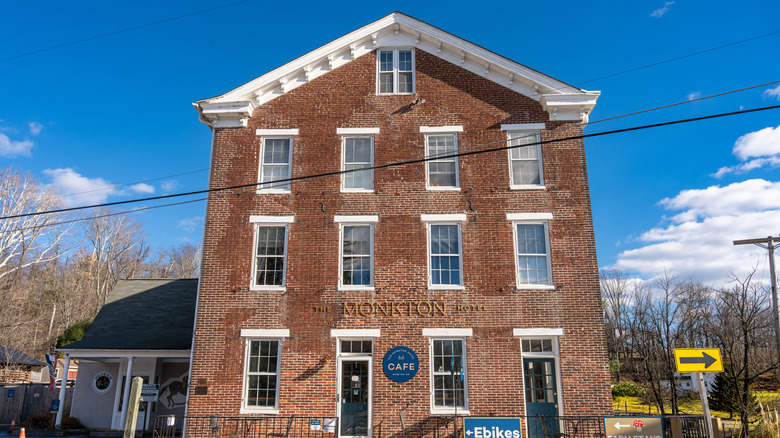 Brick front of 3-story Monkton Hotel beneath blue sky