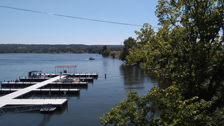 Floating boat docks extending into Lake Hudson at Iron Horse Landing Marina with lush hillsides sloping down to the water's edge, Salina, Oklahoma