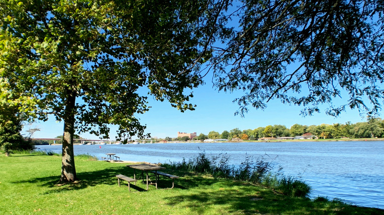 Grassy riverside picnic areas with tables and trees in Illini State Park