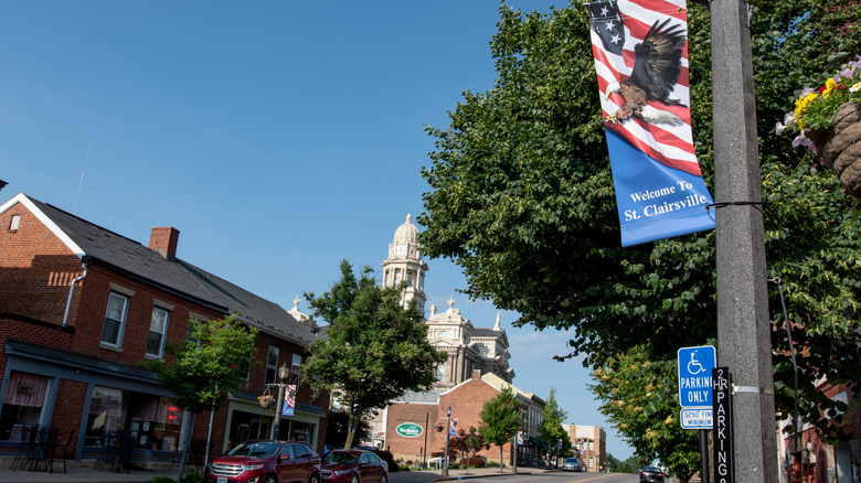 street in st.clairsville with historic buildings and welcome to st.clairsville flag