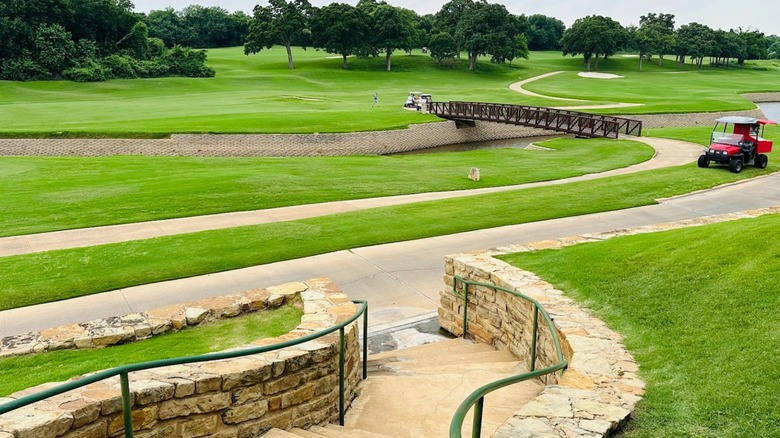 Texas Star Golf Course in Euless, Texas, featuring manicured green fairways, winding cart paths, a footbridge, and golf carts