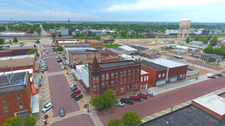 An aerial photo of downtown Lexington, Nebraska with old brick buildings, a water tower, and trees going off into the distance
