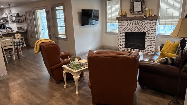cottage living room with sofa and two chairs in front of fireplace