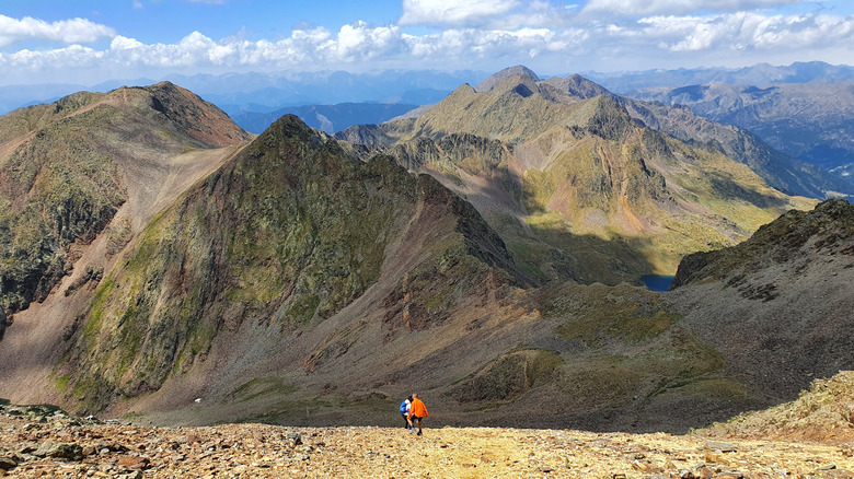 Hikers at Comapedrosa peak in Andorra surrounded by mountains