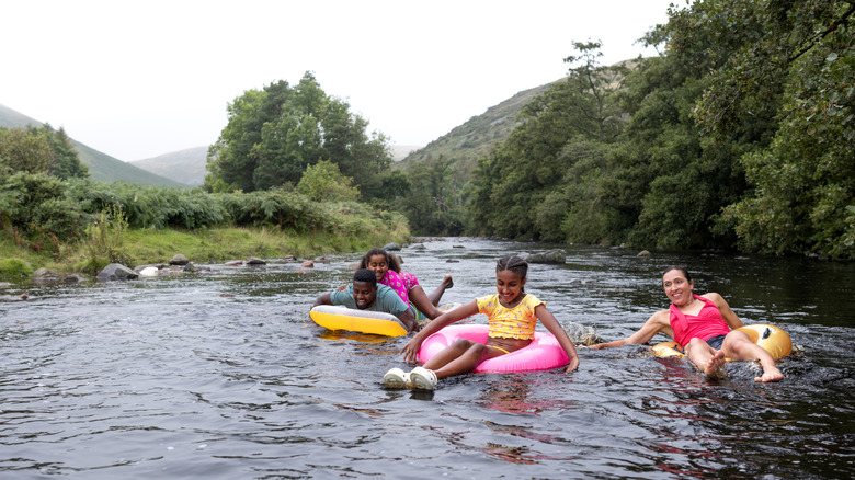 A family of four smiling while riding the rapids