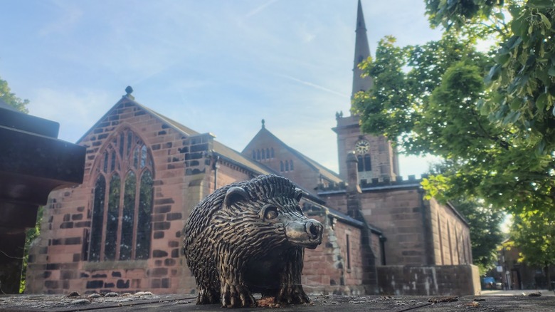 Macbeth animal sculpture in front of red-bricked parish church Prescot