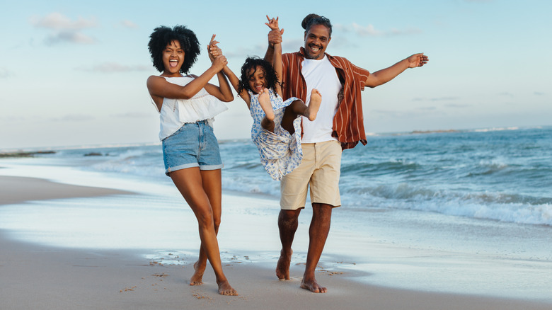 Joyful family of three on the beach