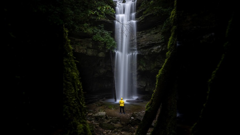 Person standing under Lost Creek Falls in Scott's Gulf Wilderness State Park