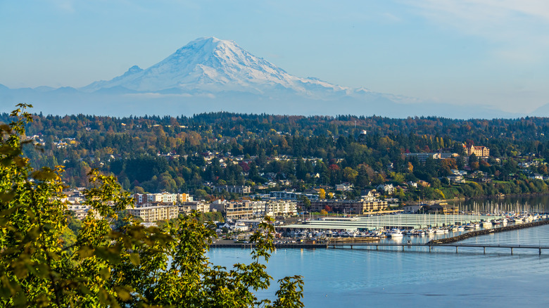 The coastal city of Des Moines and its yacht-filled marina captured with the Puget Sound in front and snow-capped Mount Rainier behind it.