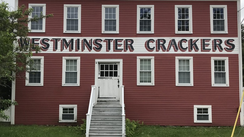 The brick-red and white exterior facade of the original Westminster Crackers bakery built in 1828 in Westminster, Massachusetts