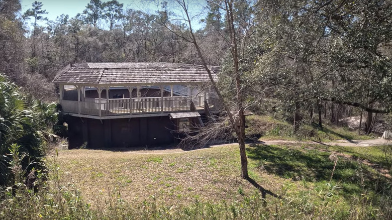 An old building that used to be home to a spring on the water with a trail leading up to it